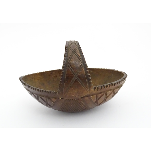 1210 - A 20thC carved coconut formed as a basket with geometric detail. Together with treen string box of b... 