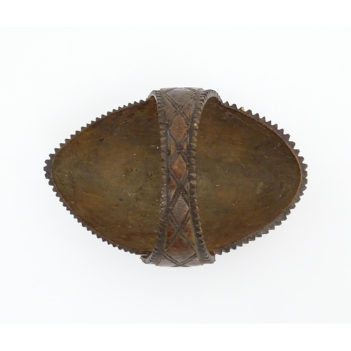 1210 - A 20thC carved coconut formed as a basket with geometric detail. Together with treen string box of b... 