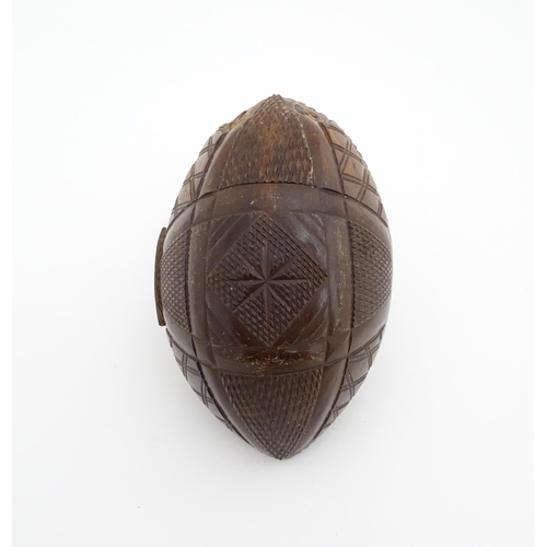 1210 - A 20thC carved coconut formed as a basket with geometric detail. Together with treen string box of b... 