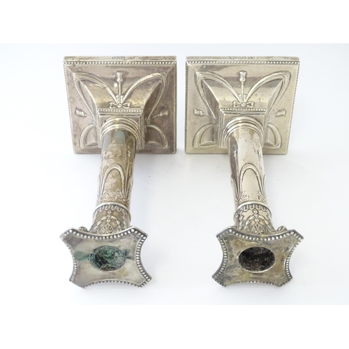 558 - A pair of Geo V silver candlesticks of column form with bow and swag detail hallmarked London 1911, ... 