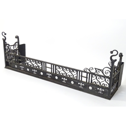 1659 - An early 20thC cast iron fire fender with pierced fleur de lys and roundel detail and scrollwork dec... 