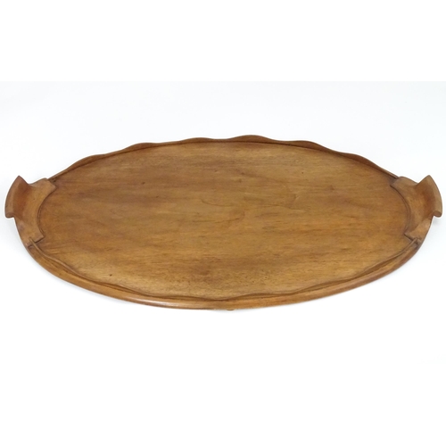 95 - A 20thC wooden tray of oval form with twin handles and lobed gallery. Approx. 27 1/2