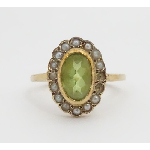 448 - A 9ct gold ring set with central peridot bordered by seed pearls