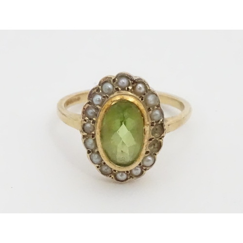 448 - A 9ct gold ring set with central peridot bordered by seed pearls