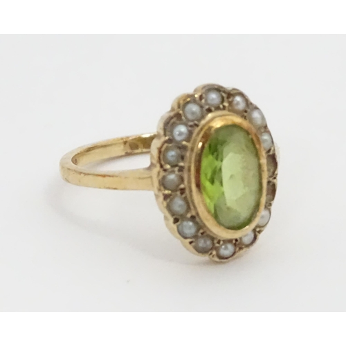 448 - A 9ct gold ring set with central peridot bordered by seed pearls