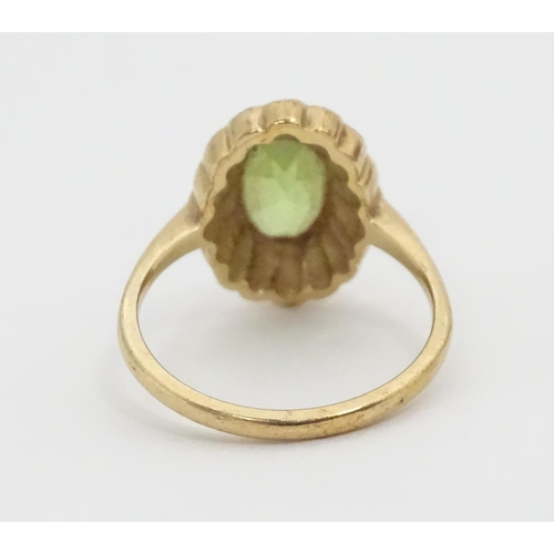 448 - A 9ct gold ring set with central peridot bordered by seed pearls