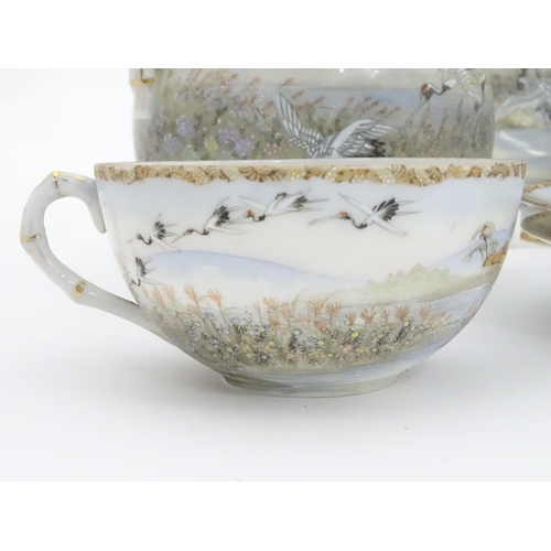 822 - A quantity of Japanese tea wares decorated with crane birds in flight to include teapot, sugar bowl,... 