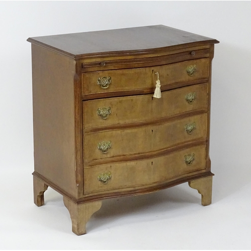 98 - A late 20thC mahogany serpentine fronted chest with a brushing slide, above a hinged door raised on ... 