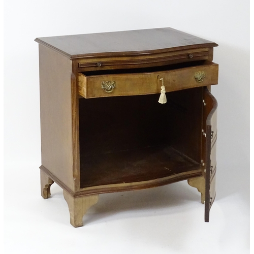 98 - A late 20thC mahogany serpentine fronted chest with a brushing slide, above a hinged door raised on ... 