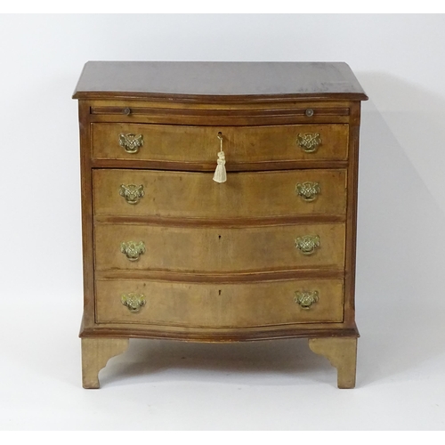 98 - A late 20thC mahogany serpentine fronted chest with a brushing slide, above a hinged door raised on ... 