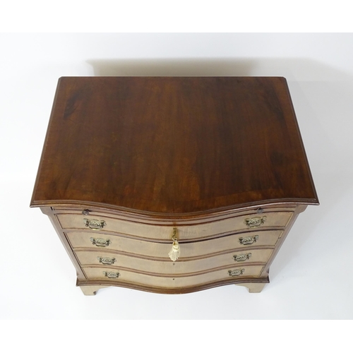 98 - A late 20thC mahogany serpentine fronted chest with a brushing slide, above a hinged door raised on ... 