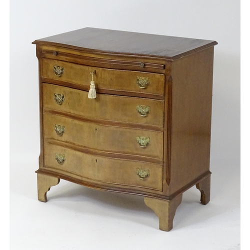 98 - A late 20thC mahogany serpentine fronted chest with a brushing slide, above a hinged door raised on ... 