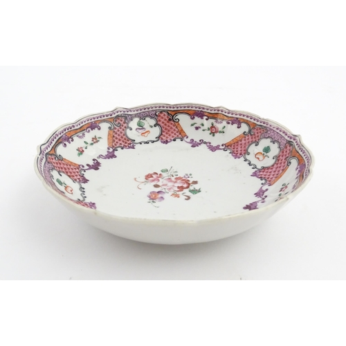 17 - A Chinese Export plate decorated with flowers and foliate with a scrolling border. Approx. 5 1/2