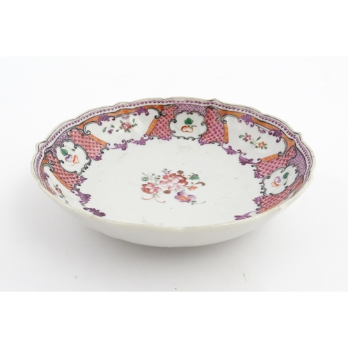 17 - A Chinese Export plate decorated with flowers and foliate with a scrolling border. Approx. 5 1/2