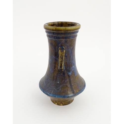 32 - An Oriental twin handled vase with a high fired glaze and banded detail to rim. Approx. 11 14/