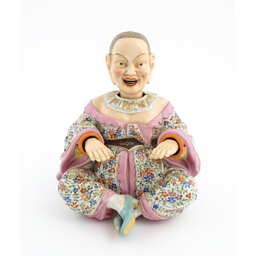 54 - An Ernst Bohne porcelain figure modelled as a seated Chinese / Oriental man with articulated head, t... 