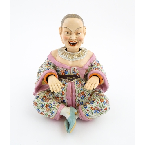 54 - An Ernst Bohne porcelain figure modelled as a seated Chinese / Oriental man with articulated head, t... 