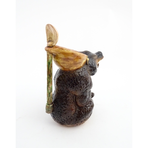 70 - A majolica bear jug modelled as a seated brown bear holding a honey pot and spoon. In the manner of ... 