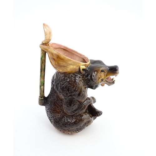 70 - A majolica bear jug modelled as a seated brown bear holding a honey pot and spoon. In the manner of ... 