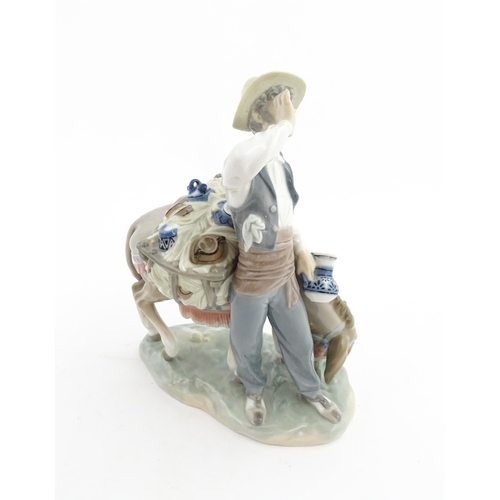 112 - A Lladro figure Typical Peddler, model no. 859, modelled as a man with a donkey. Approx. 10 1/4