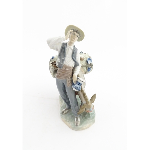 112 - A Lladro figure Typical Peddler, model no. 859, modelled as a man with a donkey. Approx. 10 1/4