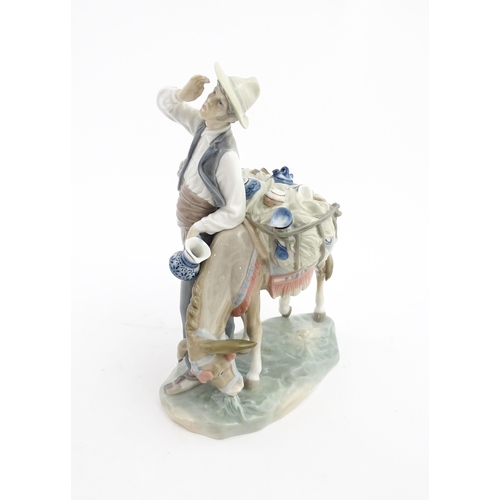 112 - A Lladro figure Typical Peddler, model no. 859, modelled as a man with a donkey. Approx. 10 1/4