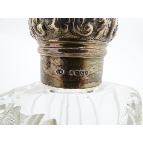 213 - A pair of Victorian cut glass scent bottles of squared form with glass stoppers and silver tops hall... 