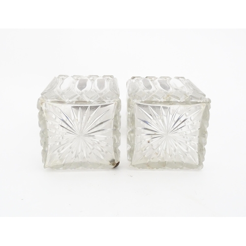 213 - A pair of Victorian cut glass scent bottles of squared form with glass stoppers and silver tops hall... 