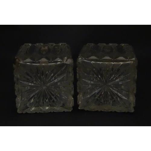 213 - A pair of Victorian cut glass scent bottles of squared form with glass stoppers and silver tops hall... 