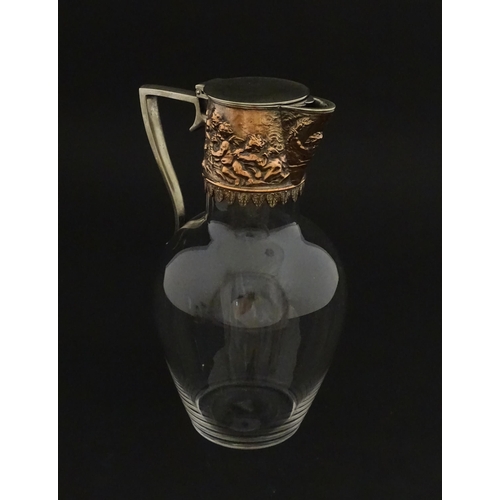 239 - An early 20thC glass claret jug with silver plate mount and handle depicting Bacchanalian figures. A... 