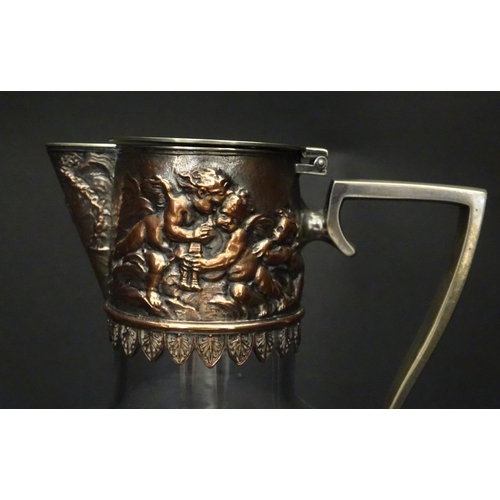 239 - An early 20thC glass claret jug with silver plate mount and handle depicting Bacchanalian figures. A... 