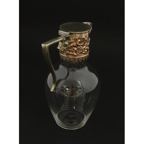 239 - An early 20thC glass claret jug with silver plate mount and handle depicting Bacchanalian figures. A... 