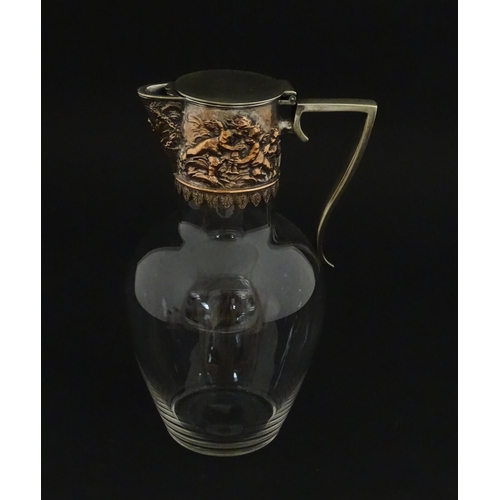 239 - An early 20thC glass claret jug with silver plate mount and handle depicting Bacchanalian figures. A... 