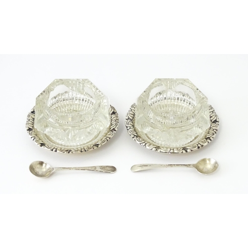 449 - A pair of cut glass salts on Egyptian silver stands together with two salt spoons hallmarked Sheffie... 