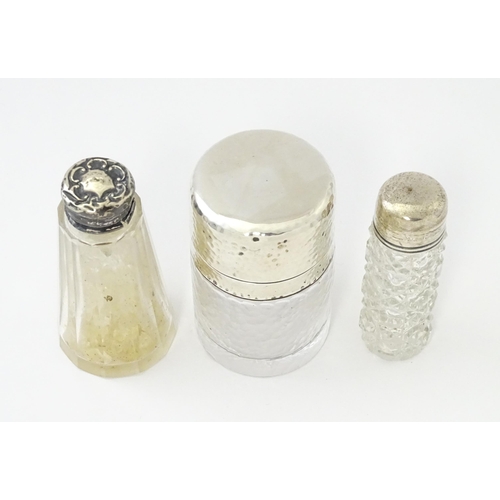 489 - Three various  glass jars / scent bottles with silver lids, one with hammered decoration hallmarked ... 