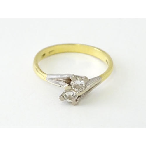 602 - An 18ct gold ring set with two diamonds. Ring size approx. O