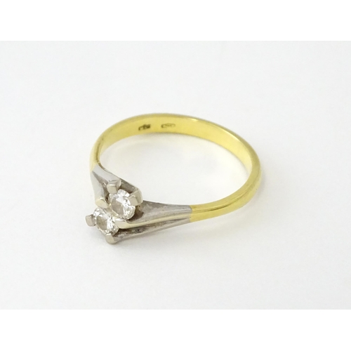 602 - An 18ct gold ring set with two diamonds. Ring size approx. O