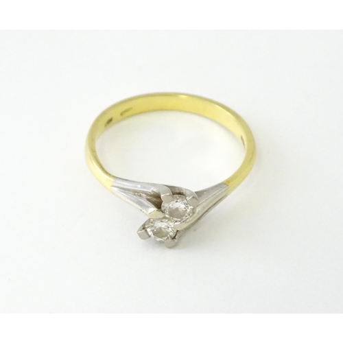 602 - An 18ct gold ring set with two diamonds. Ring size approx. O