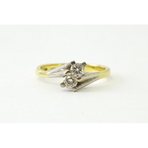 602 - An 18ct gold ring set with two diamonds. Ring size approx. O