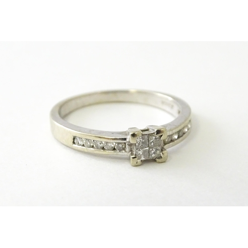 635 - A 9ct white gold ring set with four central diamonds in a square setting, flanked by five channel se... 