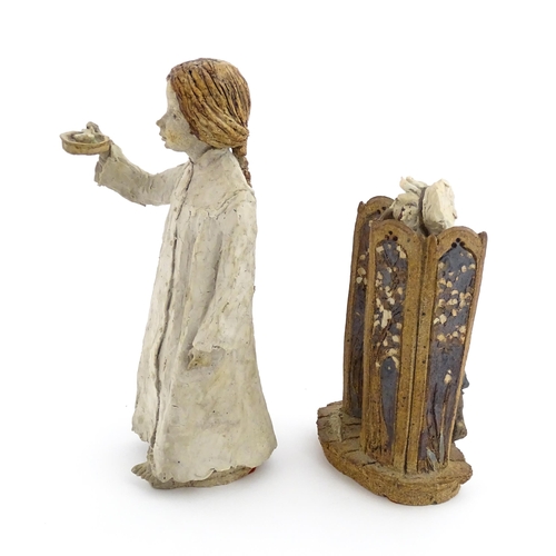 122 - Two studio pottery figurines by Graham Piggott of Blandon Pottery, one modelled as a child in a nigh... 