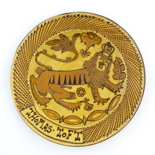 145 - A large slipware charger in the manner of Thomas Toft, decorated with a heraldic lion to centre. App... 