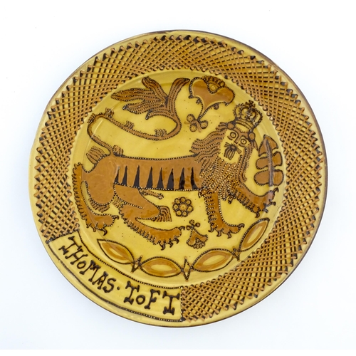 145 - A large slipware charger in the manner of Thomas Toft, decorated with a heraldic lion to centre. App... 