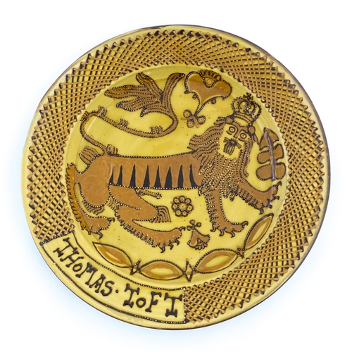 145 - A large slipware charger in the manner of Thomas Toft, decorated with a heraldic lion to centre. App... 