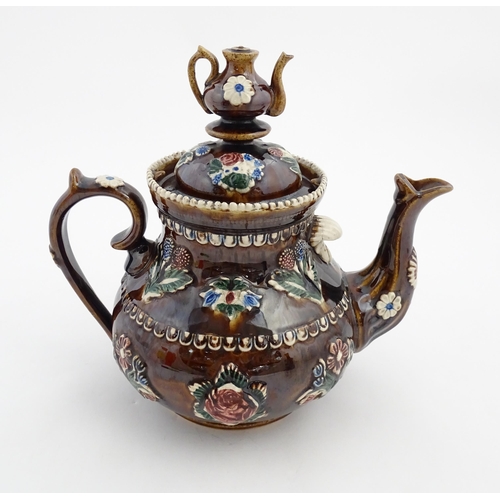 149 - A Victorian Measham bargeware teapot with a teapot finial to lid, decorated with flowers, foliage, r... 