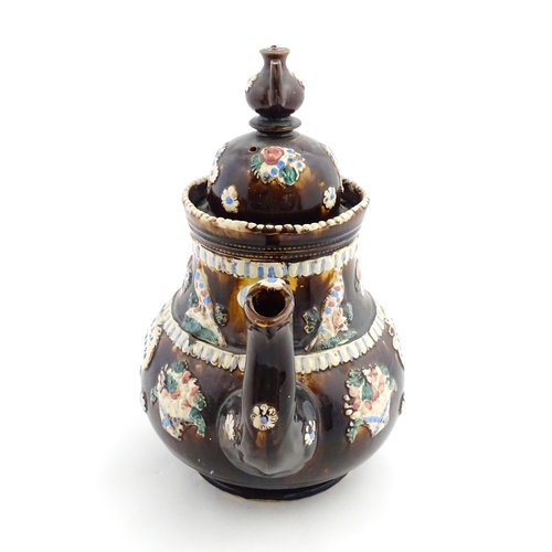 154 - A large Measham bargeware teapot with teapot finial to lid, decorated with baskets of flowers, birds... 