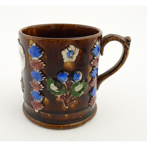 155 - A Victorian Measham bargeware large mug with flower detail and plaque titled Forget Me Not. Approx. ... 