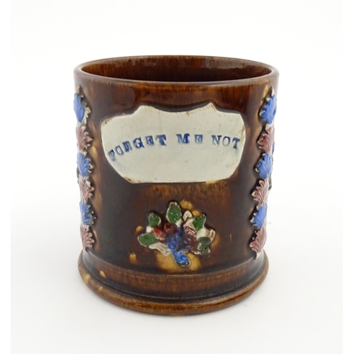 155 - A Victorian Measham bargeware large mug with flower detail and plaque titled Forget Me Not. Approx. ... 