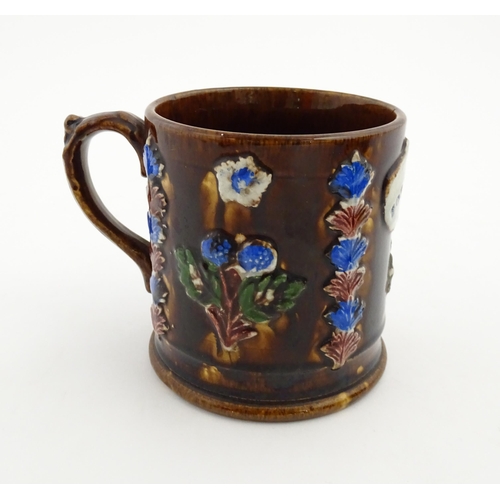 155 - A Victorian Measham bargeware large mug with flower detail and plaque titled Forget Me Not. Approx. ... 