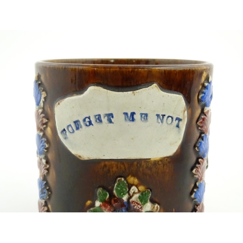 155 - A Victorian Measham bargeware large mug with flower detail and plaque titled Forget Me Not. Approx. ... 